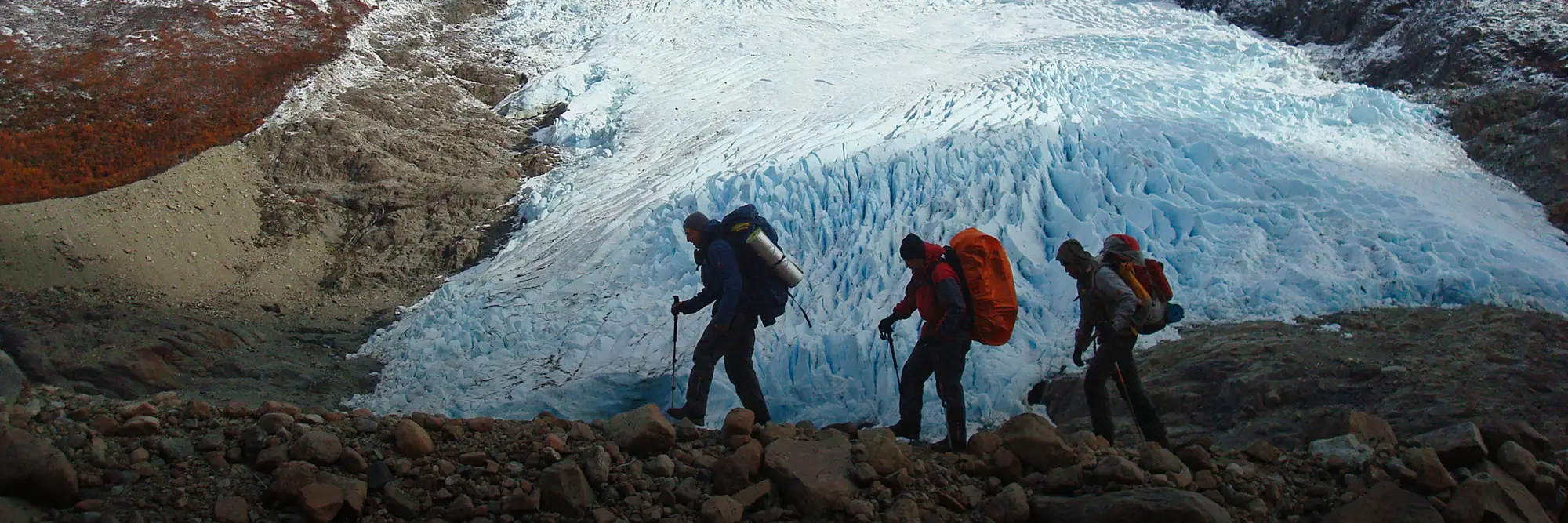 Grupo de excursionistas realizando trekking en ambiente glaciar.